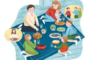 床に座って伝統的な夕食を楽しむ家族。