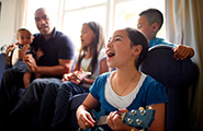 Family singing and playing instruments on a couch