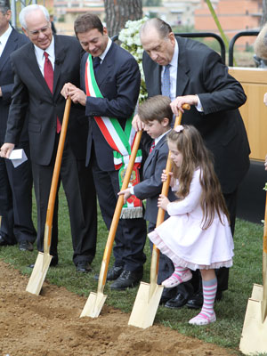 El presidente Monson ayuda a dos niños durante la ceremonia de la palada inicial.