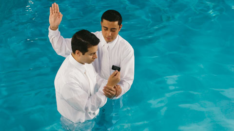 a man baptizing another man
