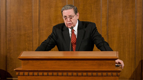 El élder Jeffery R. Holland en una conferencia de prensa