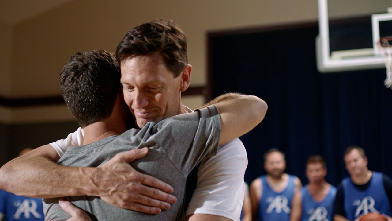 Two men hug on the basketball court