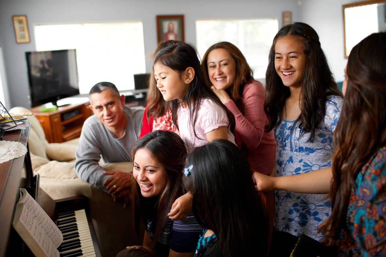 A family gathered around the piano together