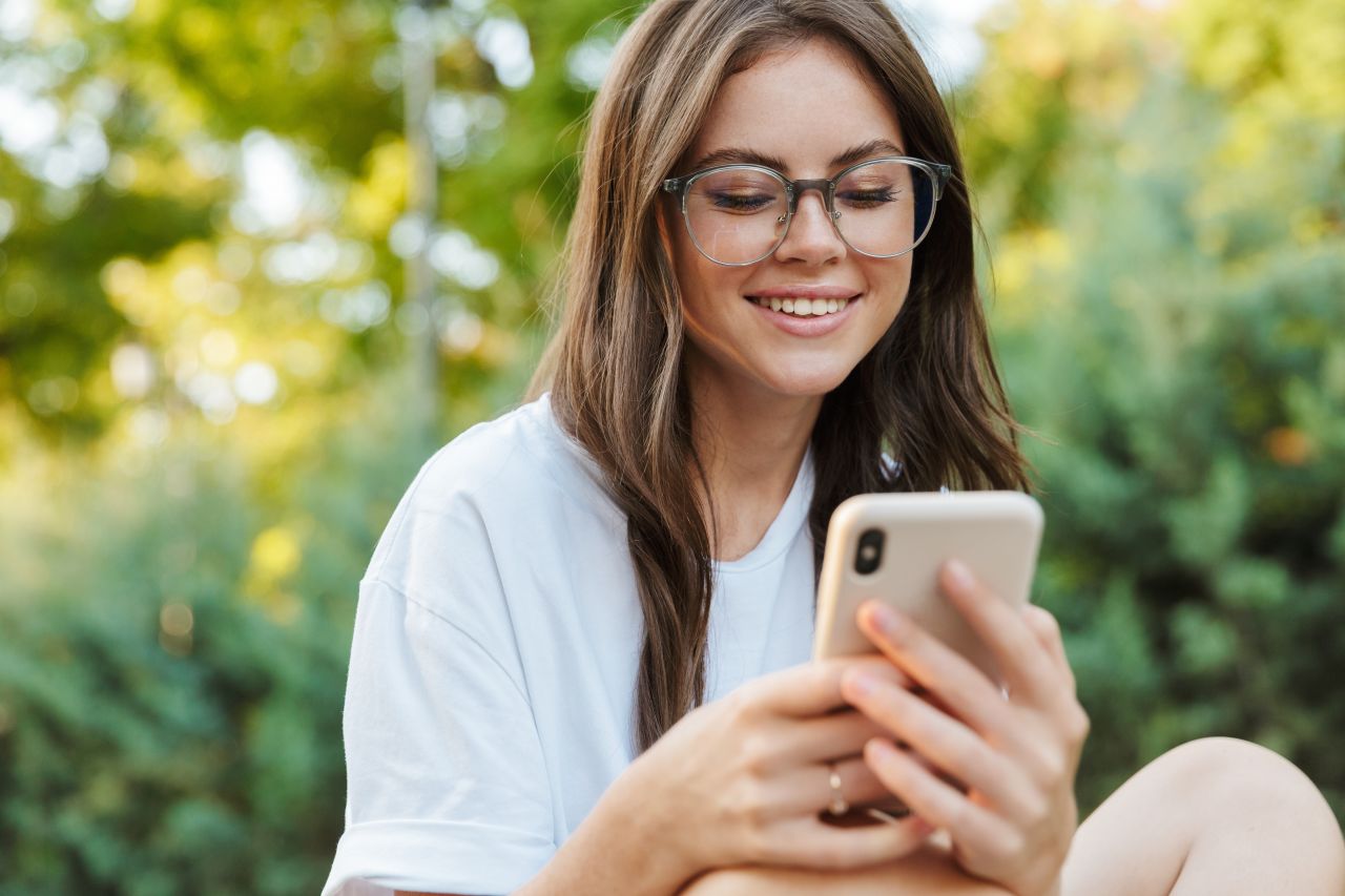A woman looks at her mobile phone