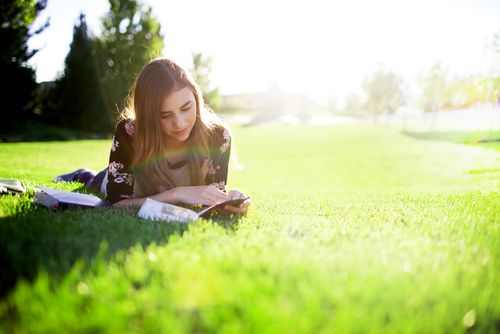 young woman reading on grass