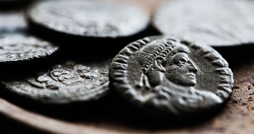 A close up of an ancient coin among other coins