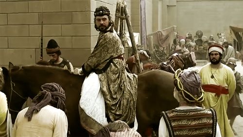 Mordecai watching Haman ride through the streets on a horse