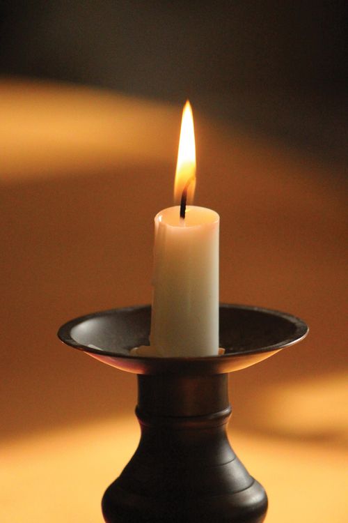 A candle burning in a candlestick.