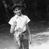 Thomas S. Monson as a boy.  He is holding fish that he has caught.