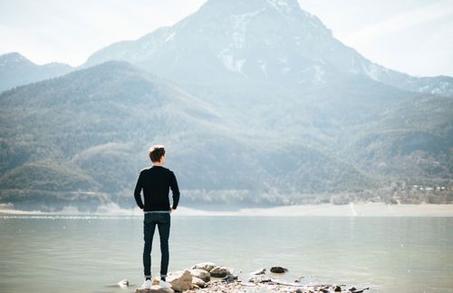 年輕成人男子站在湖邊