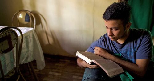 Nuori mies tutkimassa pyhiä kirjoituksia