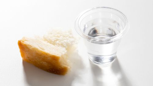 a piece of bread and a sacrament cup filled with water