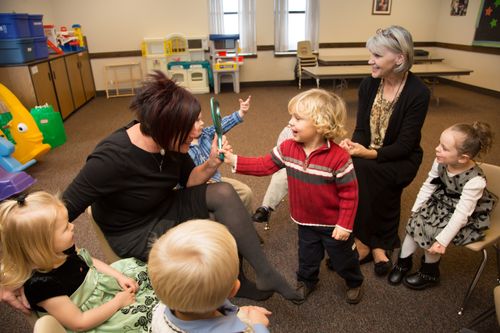 A photo of nursery-age children singing and interacting.