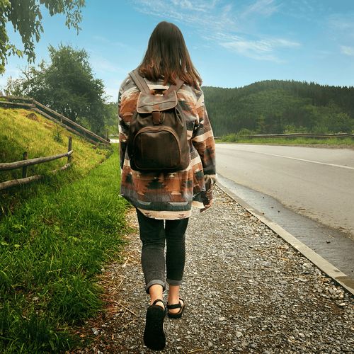 young woman walking along road