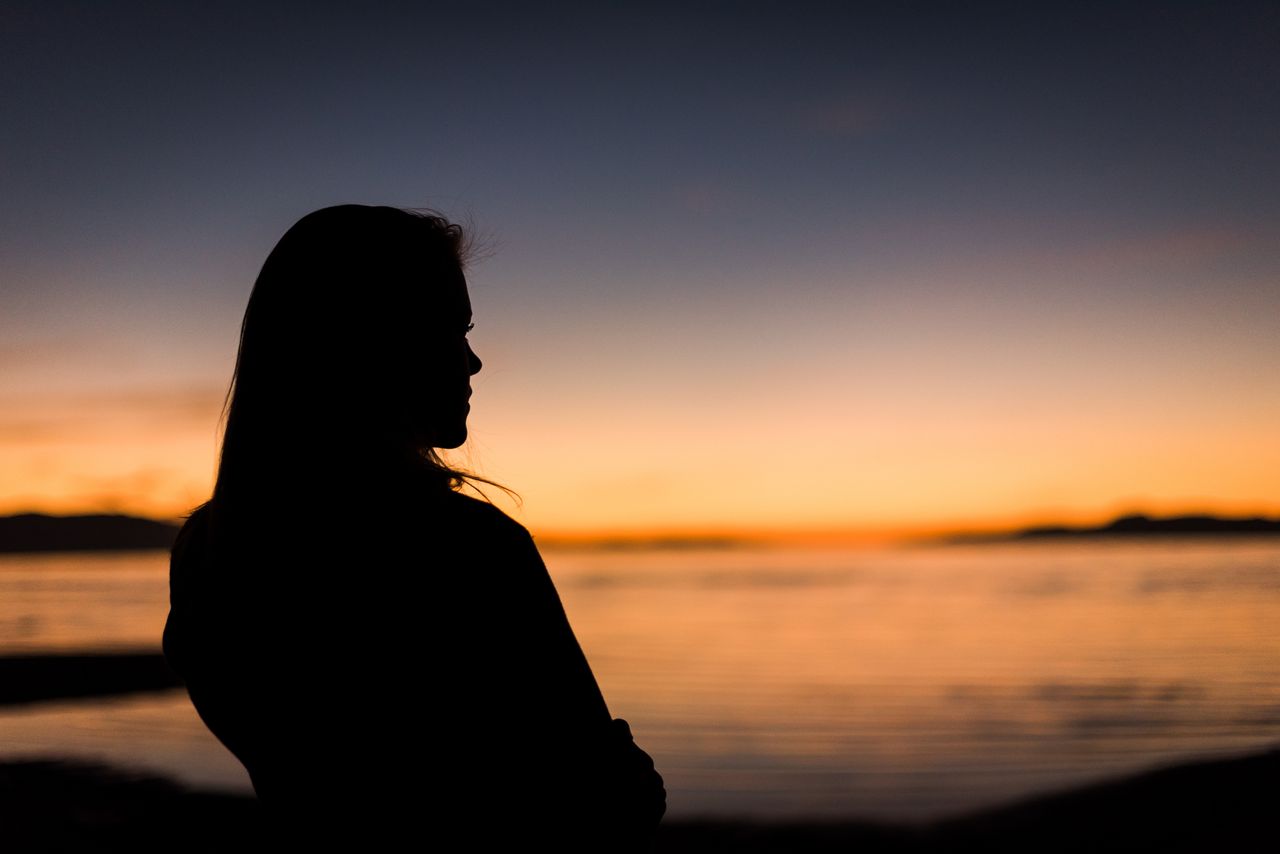 Uma silhueta de uma mulher ao pôr do sol