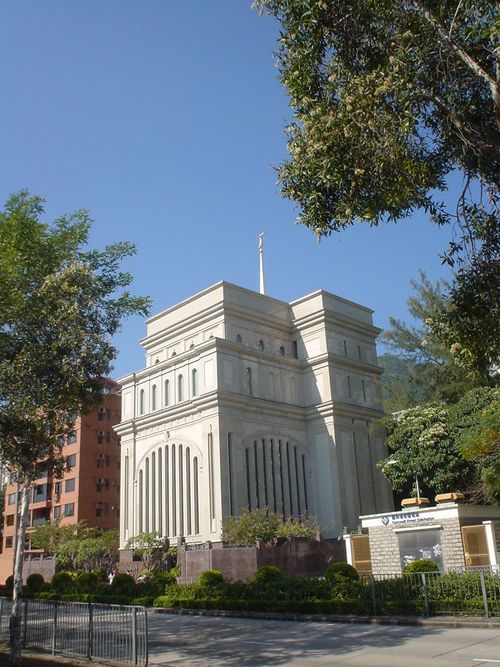 A view of the Hong Kong China Temple from across the street, with large trees growing in the foreground.