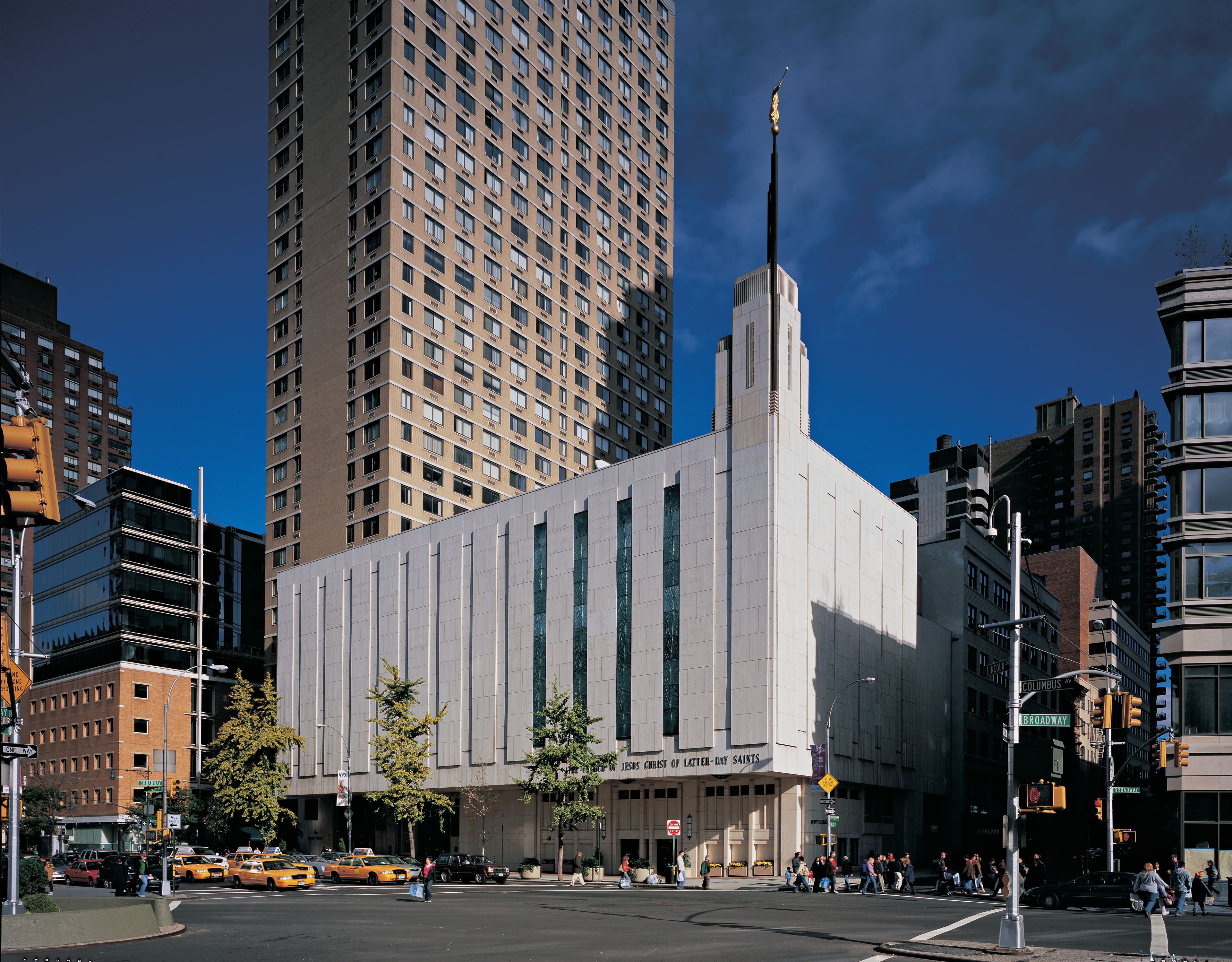The Manhattan New York Temple against a dark sky, including the entrance and scenery.