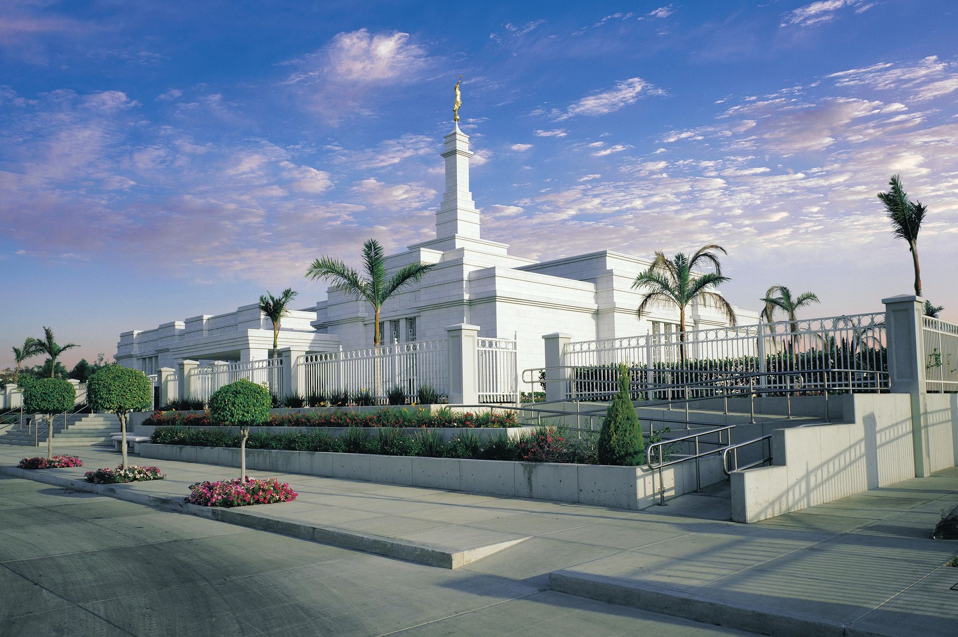 The Guadalajara Mexico Temple and grounds on a partly cloudy day.