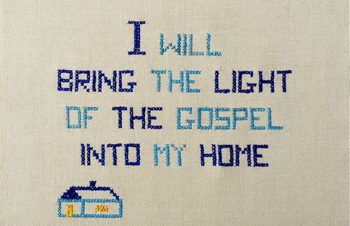 Kryželiu išsiuvinėtas posakis „Savo namuose skleisiu Evangelijos šviesą“