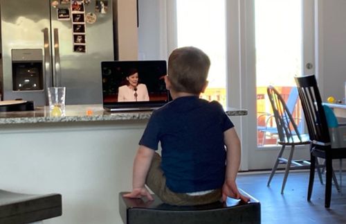 a little boy sitting on a stool and watching President Porter speak about prayer