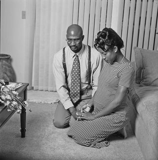 Par som knäböjer i bön
