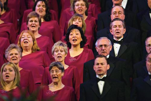 Men and women in the Mormon Tabernacle Choir singing in the Conference Center.