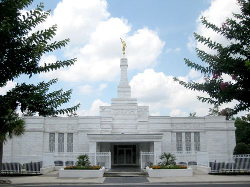 The front entrance of the Columbia South Carolina Temple, with a large green tree on either side.