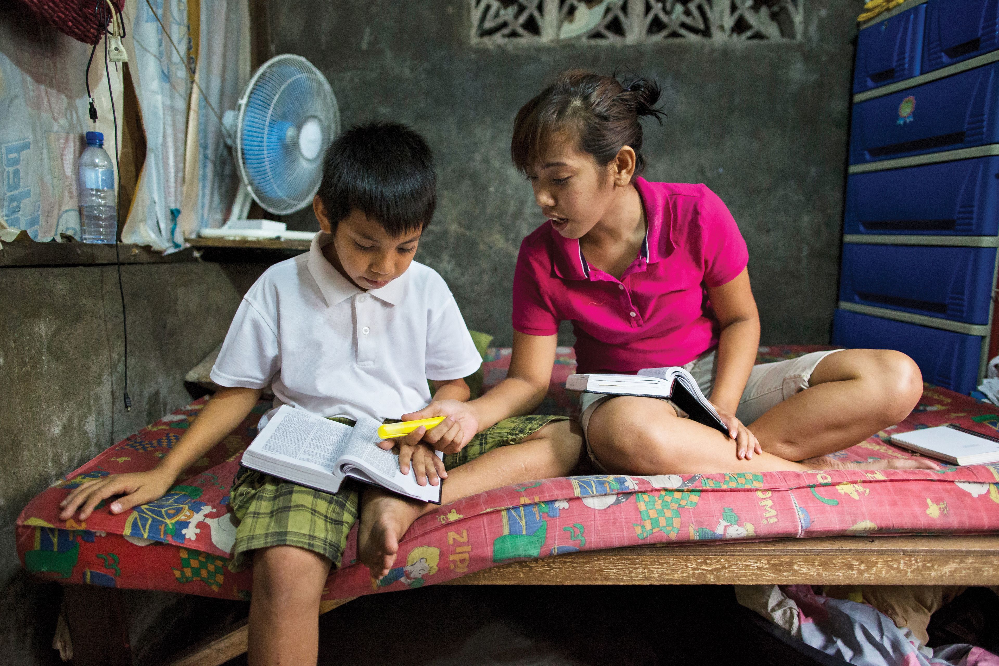 Siblings studying scriptures in the Philippines.