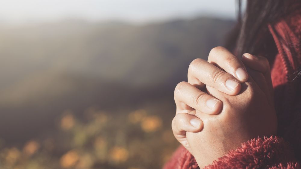 Woman hands folded in prayer.