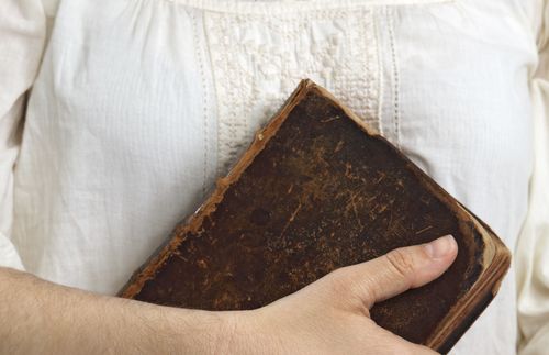 woman holding old Bible