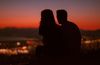 a couple sitting and watching a sunset