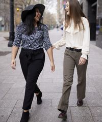 Various sister missionaries model appropriate dress and attire as they walk together. They are wearing approved blouses, and pants.