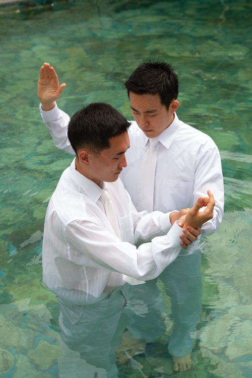 Een jongeman wordt gedoopt