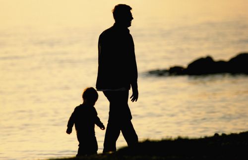 father and son walking on a beach