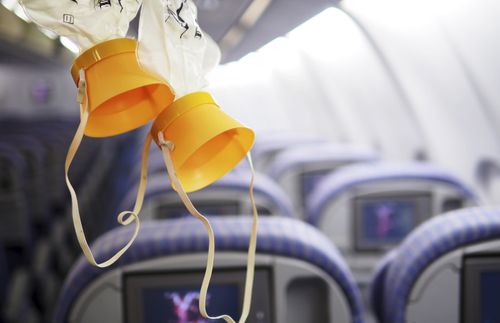 masker dat aan het plafond van een vliegtuig hangt
