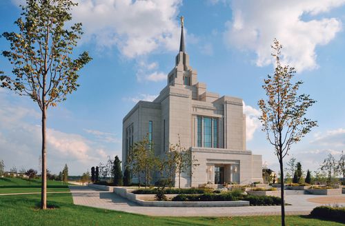 The front of the Kyiv Ukraine Temple on a partly cloudy day, with several small trees growing on the grounds.
