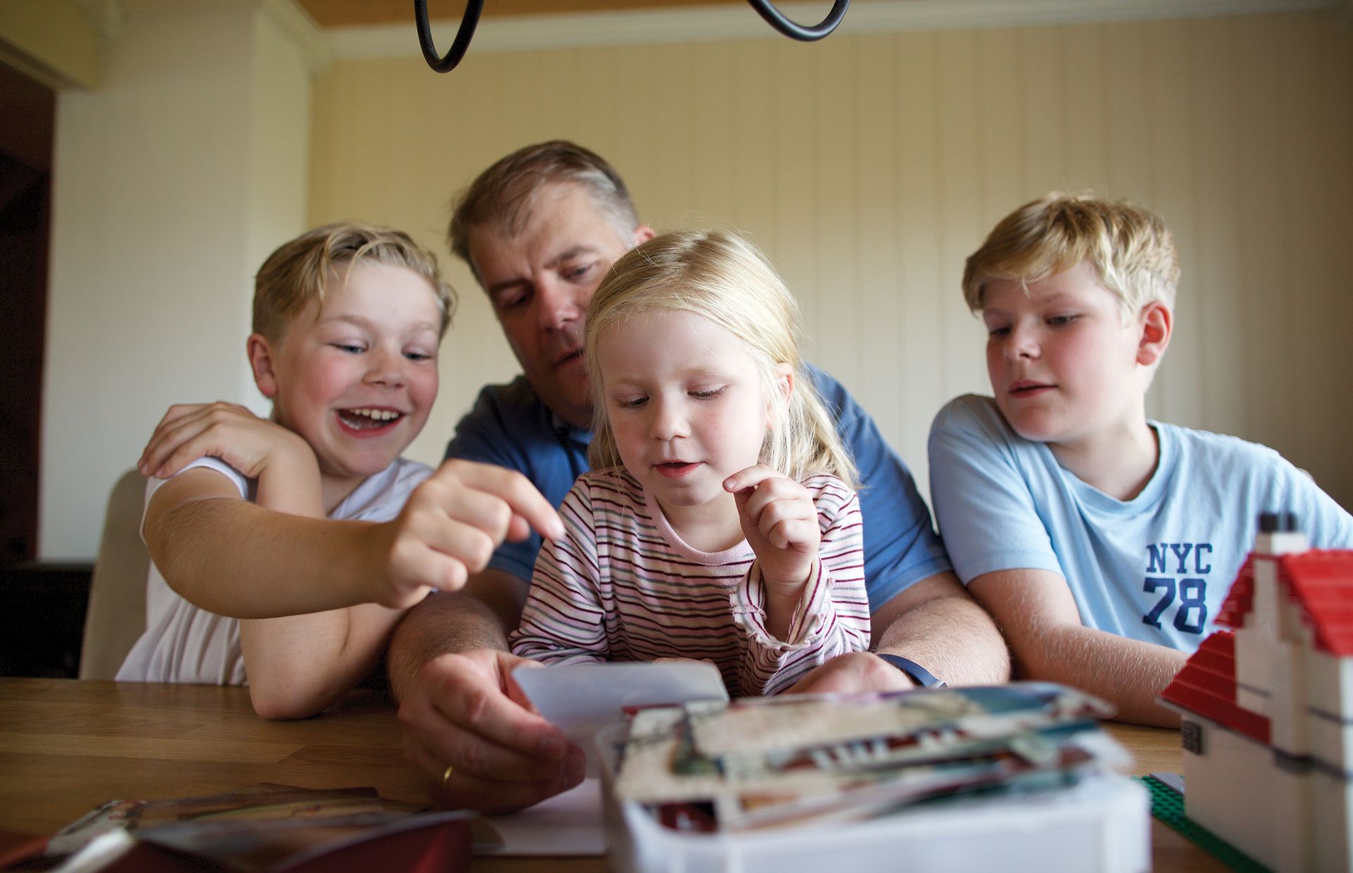 Кристиан и его дети рассматривают семейные фотографии. Кристиан благодарен за возможность создать связь между его детьми и их предками.