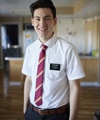 A missionary models appropriate shirts and ties and he smiles and talks to someone off camera.