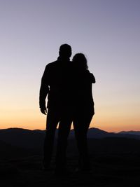 young man and young woman looking at sunset