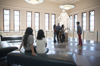Various people look at the Christus statue in the Conference Center.