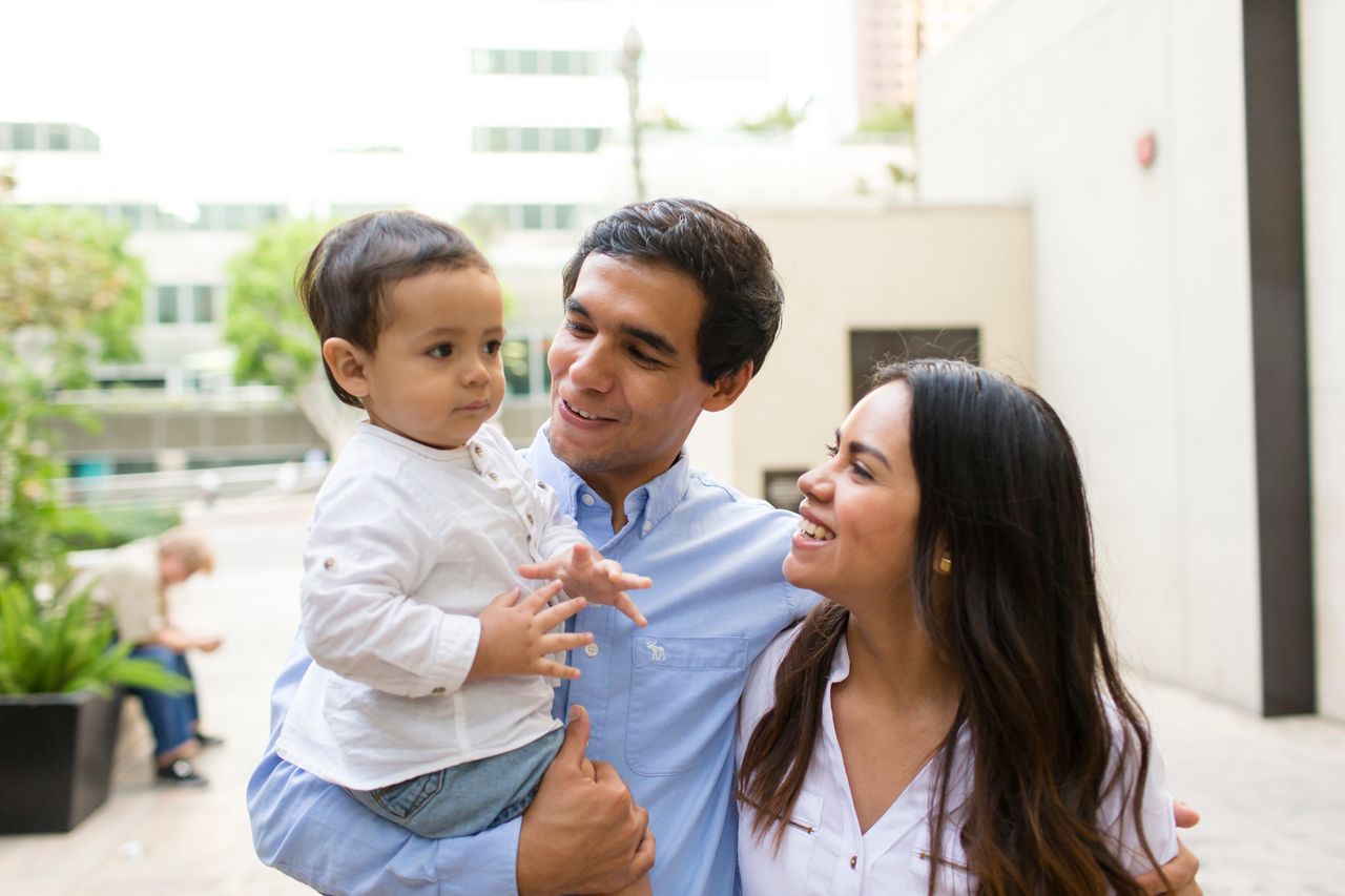Casal segurando sua criança e sorrindo