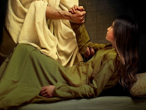 Photographic illustration of Jesus Christ healing the daughter of Jairus.   The image shows the figure (not the face) of Christ as he takes the young girl by the hand and assists her to rise from her sick bed.