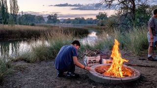 A young man Starting a campfire at Burraston Ponds, Utah