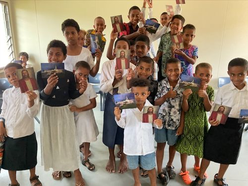 Primary children holding up pictures of the Savior and the temple