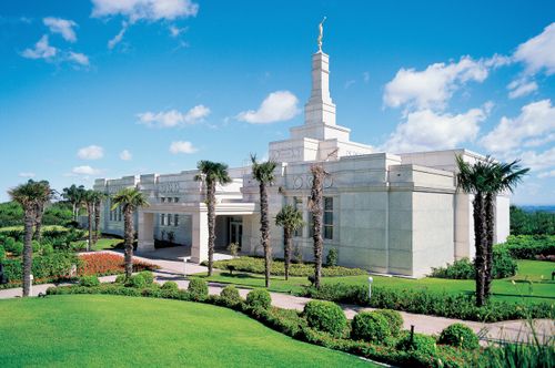 The Porto Alegre Brazil Temple and grounds seen from a distance, with palm trees growing on the grounds.