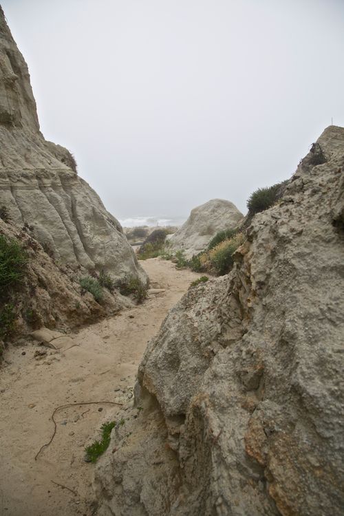 a dirt path through a rocky valley