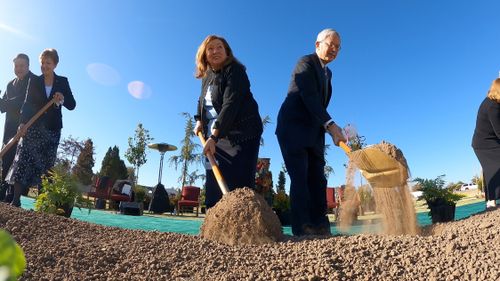 Elder and Sister Gong digging at temple groundbreaking