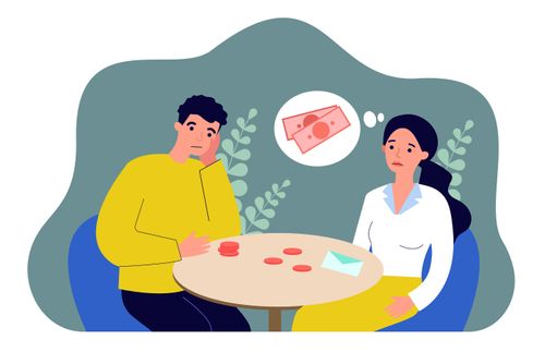 a couple sitting at a table and worrying about money