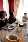 خانواده‌ای درحال دعا کردن سر میز غذا