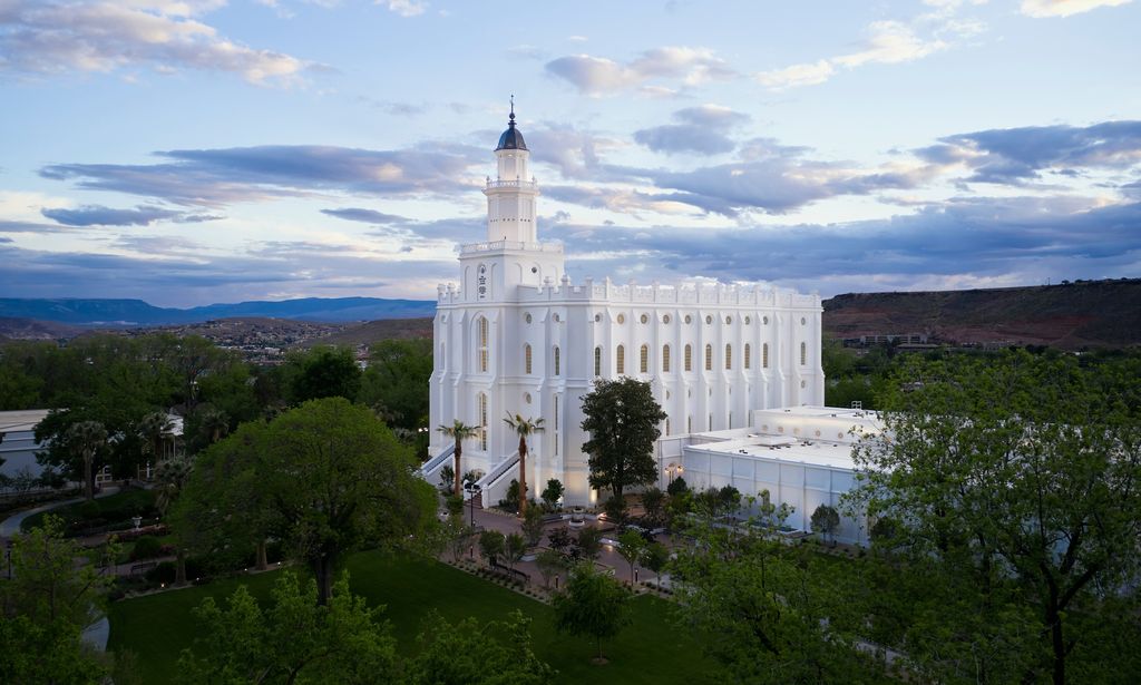 Exterior image of the St. George Utah Temple. The image features the temple set around trees surrounding the temple grounds. 